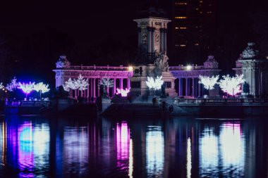 Madrid, İspanya - 17 Aralık 2021 Madrid 'deki Retiro Park Gölü, gölete yansıyan Noel Işıkları ile aydınlandı