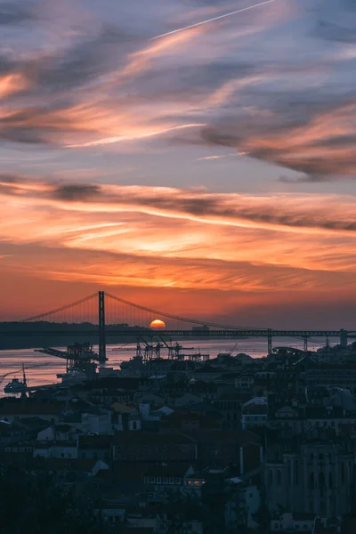 ポルトガルのタガス川にあるリスボンのバイシャと4月25日の橋を見下ろす夕日 — ストック写真