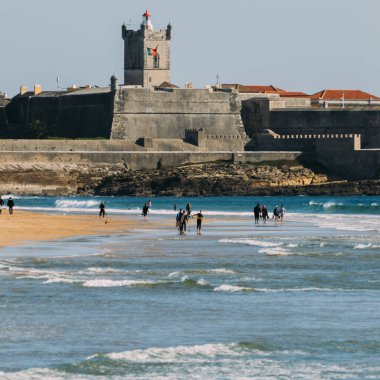 Carcavelos Beach, Portekiz - 5 Şubat 2022: Carcavelos plajında sörfçüler, Lizbon Bölgesi, Portekiz 'in tarihi kalesi