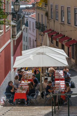 Lizbon, Portekiz - 4 Haziran 2022: Alfama, Lizbon 'un Castelo Sao Jorge ve Baixa' ya bakan eski sokaklarındaki açık kafe