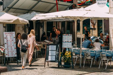Lizbon, Portekiz - 4 Temmuz 2022: Portekiz 'in en eski bölgelerinden biri olan Portekiz' in dar sokaklarında turistler ve yer göstericiler
