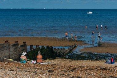 Whitstable, İngiltere - 16 Temmuz 2022: İnsanlar sıcak bir yaz gününde Whitstable, Kent, İngiltere 'de plajda dinleniyor