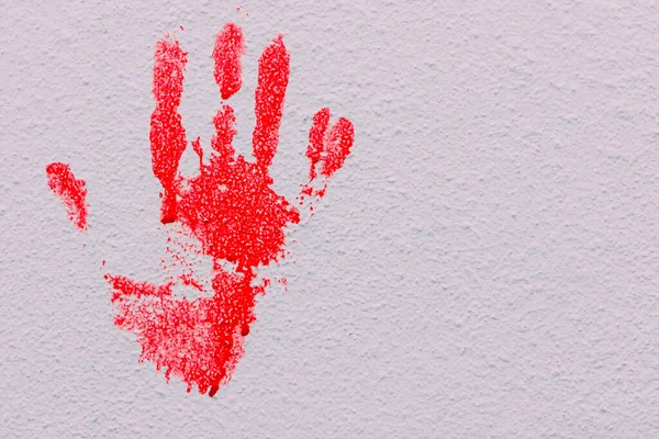 Bloody print of a bleeding hand dripping on a white background