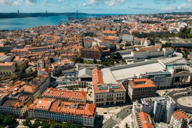 Aerial drone view of Rossio rail station looking west towards 25 April Bridge on Tagus River in Lisbon, Portugal