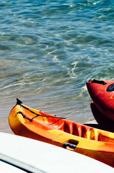 Active rest, sport, kayak. Boat for rafting on water. A few kayaks stand on a sandy beach.