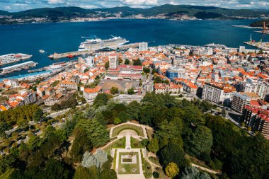 Vigo, Galiçya limanına demirlemiş gemiler ve dev yolcu gemileri ön planda Monte do Castro ile İspanya