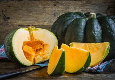 Tahta bir masada dilimlenmiş balkabağı meyveleri..