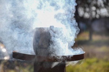 Dışarıdaki bir su ısıtıcısında, yanan bir odun sobasında. Zor zamanlar, nasıl hayatta kalınacağı. Açık hava yemekleri..