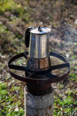 Bahçede, odun yakan bir ocakta gayzer kahve makinesinde kahve yapmak. Güzel bir sonbahar günü.
