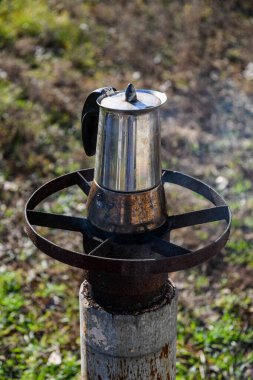 Bahçede, odun yakan bir ocakta gayzer kahve makinesinde kahve yapmak. Güzel bir sonbahar günü.