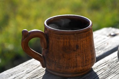 Bahçedeki gayzer kahve makinesinde hazırlanmış seramik bir fincan kahve..