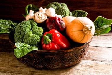 Brokoli, domates, dolma biber, mantar, ahşap bir meşe ağacında seramik bir tabakta balkabağı soğanı. Sebze..