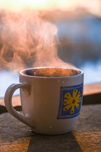 在冬日的阳台上 在升起的太阳的映衬下 喝一杯咖啡 — 图库照片