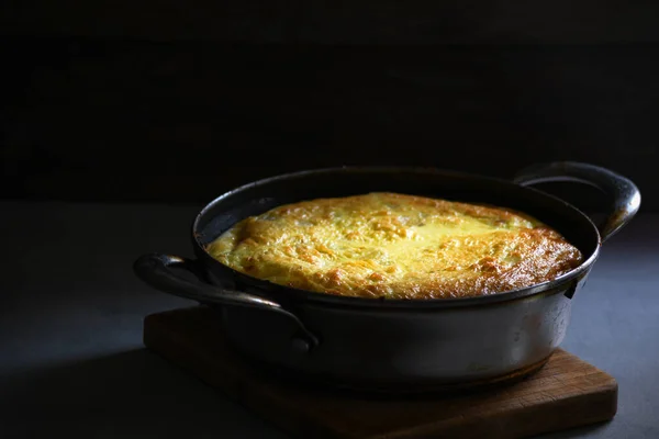 Mutfak masasındaki metal tavada patatesli kırsal omlet..