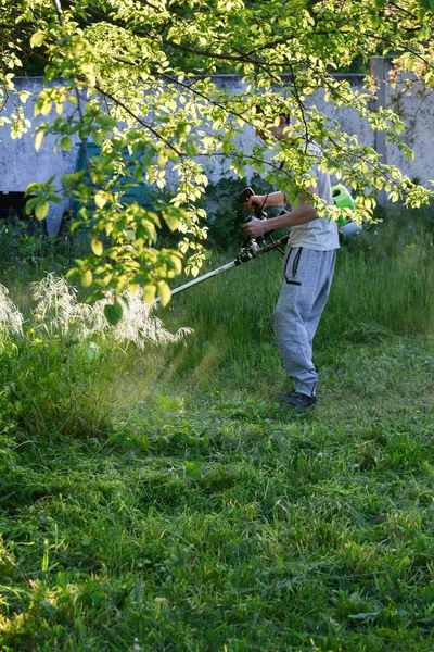 Guy Mows Cuts Cuts Grass Overgrown Garden Garden Trimmer Moto — Stock Photo, Image