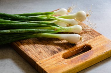 Mutfaktaki kesme tahtasındaki taze taze taze soğanlar. Ev ürünleri.