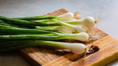 Mutfaktaki kesme tahtasındaki taze taze taze soğanlar. Ev ürünleri.