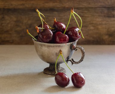 Masada olgun kirazlı gümüş bardak.