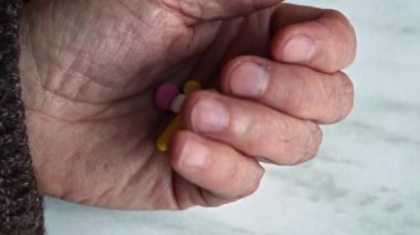 Yaşlı kadın eli haplı..