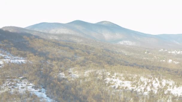 4K一部雪に覆われた落葉樹の山脈を飛行する空中ビュー — ストック動画