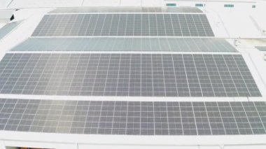 Güneş panelleriyle çatıdan insansız hava aracı uçuşu. Modern fabrika endüstriyel deposunun çatısındaki güneş panelleri. Temiz yenilenebilir enerji üretiyor. Güneşli bir günde güneş enerjisi.