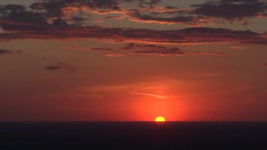 Big bright yellow sun moves down over the horizon. Time Lapse. Awesome epic cloud space. Amazing vibrant sundown
