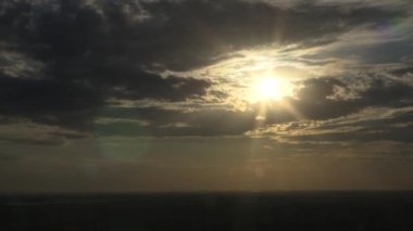 Time lapse of majestic sunset  landscape.Amazing time lapse of  fluffy clouds moving softly on the sky and the sun shining through the clouds with beautiful rays and lens flare.
