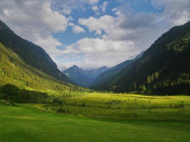 Güzel vadileri ve dağ tepeleri olan manzaralı dağ manzarası, yeşil çimenler, bulutlu gökyüzü. Yeşil, mavi. Schladminger Tauern, Alpler, Avusturya.
