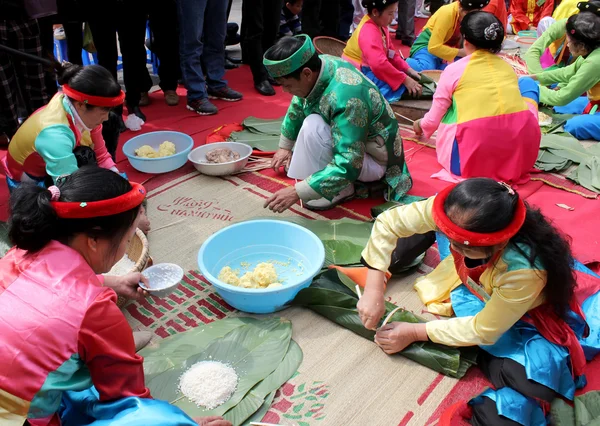 Люди в традиционных костюмах экзамен, чтобы сделать квадратный клейкий рис — стоковое фото