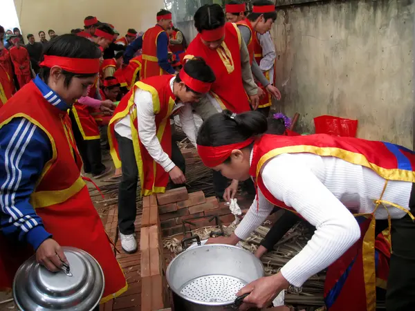 Menschen in Tracht machen runde klebrige Reiskuchen — Stockfoto