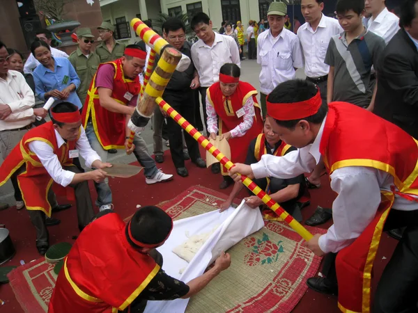 Menschen in Tracht machen runde klebrige Reiskuchen — Stockfoto