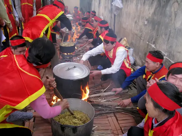 Människor i traditionell dräkt examen att göra runda klibbigt ris cak — Stockfoto