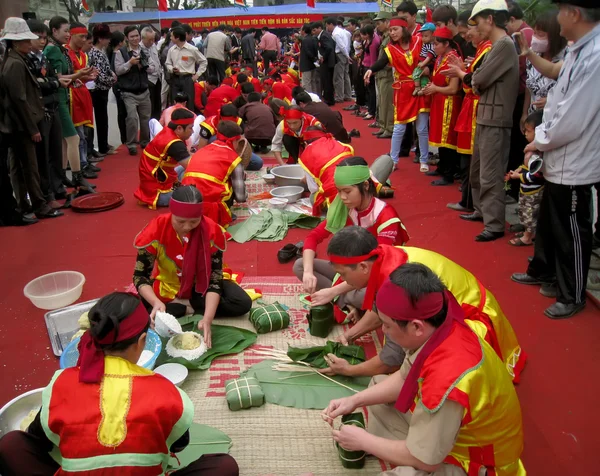 Pessoas no exame de traje tradicional para fazer arroz glutinoso quadrado — Fotografia de Stock