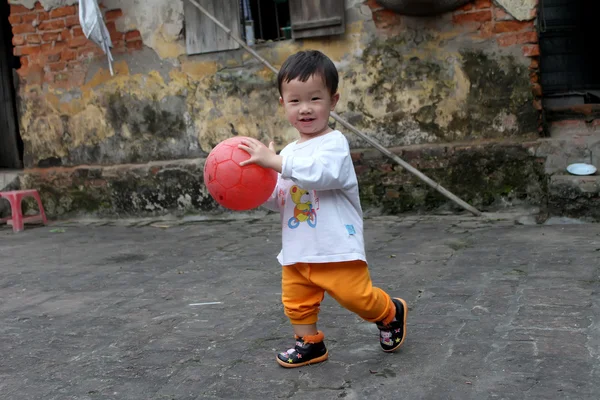 Мальчик играет в футбол во дворе — стоковое фото