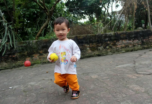 Garçon jouer au football dans la cour — Photo