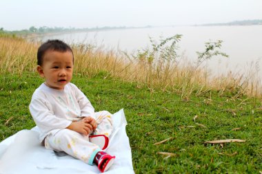 çimlerde oturan çocuk