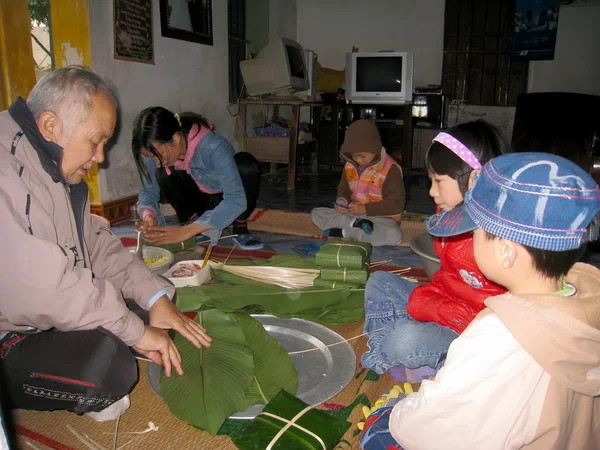 Una familia rural hacer el pastel de arroz tradicional — Foto de Stock