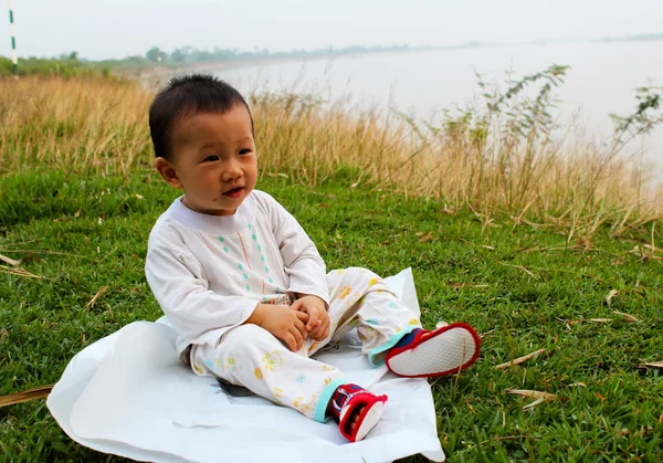 Мальчик сидит на траве — стоковое фото