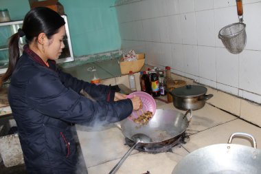 kadın Şef kızarmış ağustosböcekleri işlemek