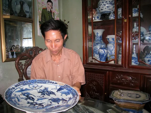 Uomo raccogliendo porcellana antica — Foto Stock