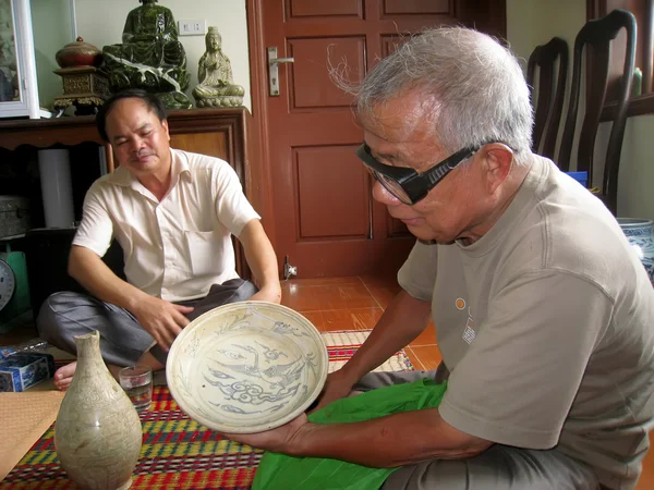 Азиатский мужчина коллекционирует античный фарфор — стоковое фото