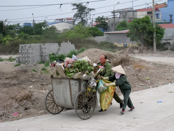 Рабочие подметают и собирают мусор на дороге — стоковое фото