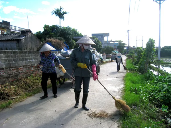 Travailleurs balayent et ramassent les ordures sur la route — Photo