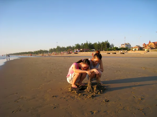 Girls build sand castles on the coast — Stock Photo, Image