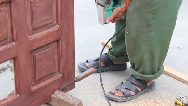 Trabajador utiliza cepilladoras de madera haciendo puerta de madera — Vídeo de stock