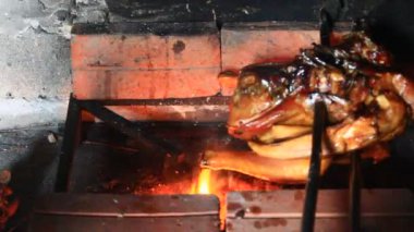 Mutfakta tavuk ızgara yapan adam.