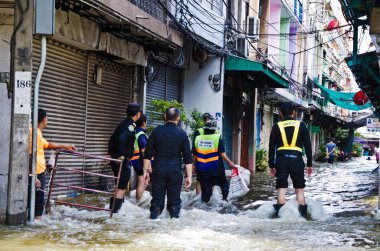 Unidentified people try to protect Bangkok from flood during the worst flooding in Bangkok, Thailand clipart
