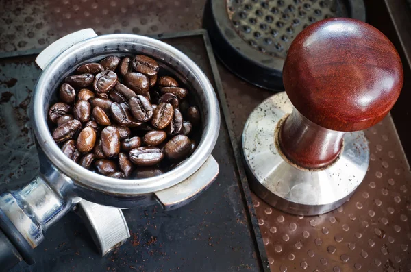 Espresso filter filled with coffee beans and tamper — Stock Photo, Image