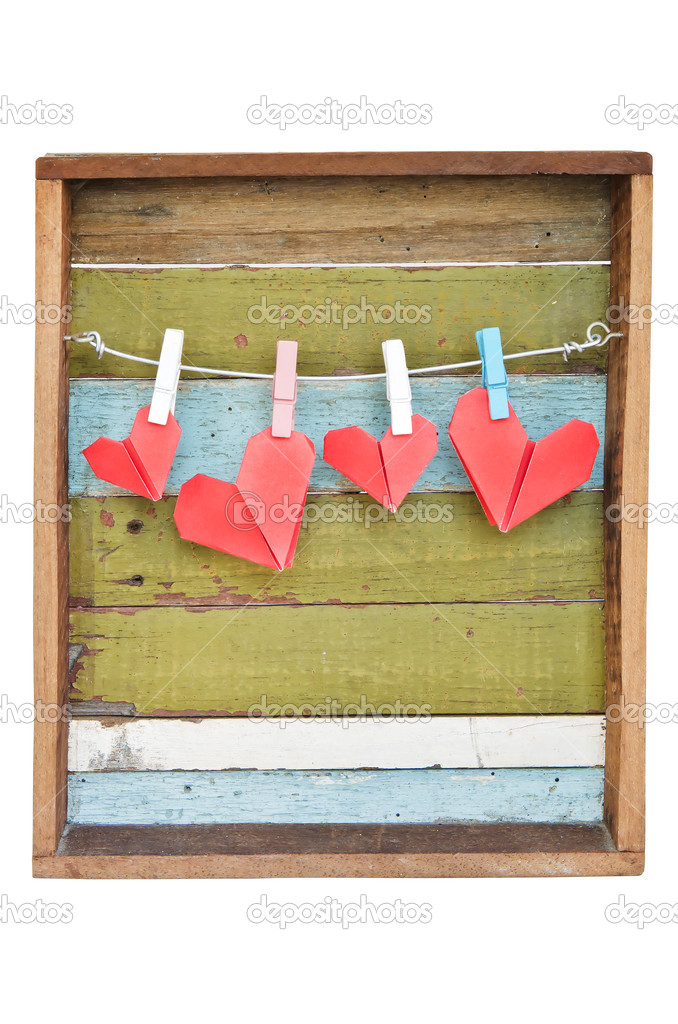 paper heart hanging on the clothesline. On old wood background.