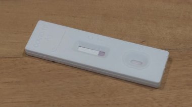 Tahta masadaki hızlı COVID-19 Antijen test kiti testinin 4K zaman aşımı sonucu negatif çıktı. Evde Self Express Coronavirus testi.